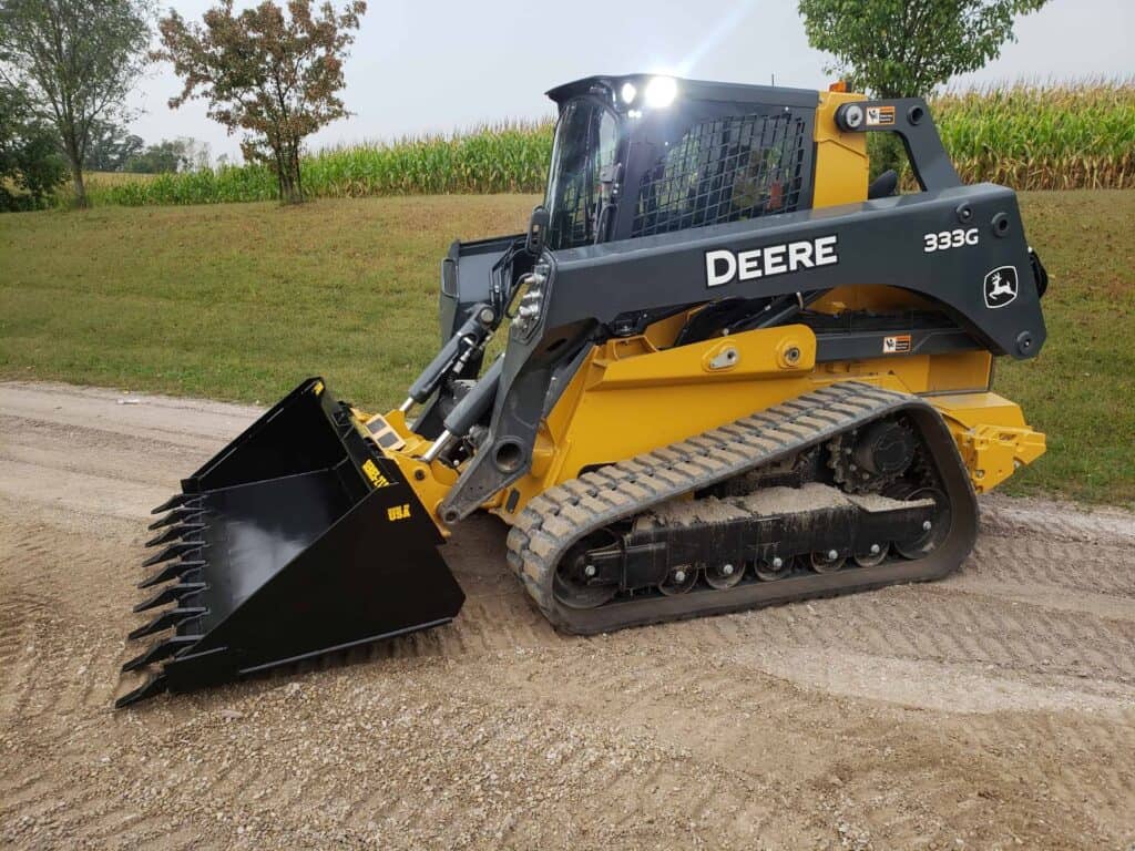 John Deere skid steer with Stinger tooth bucket attachment for digging dirt, gravel and construction materials