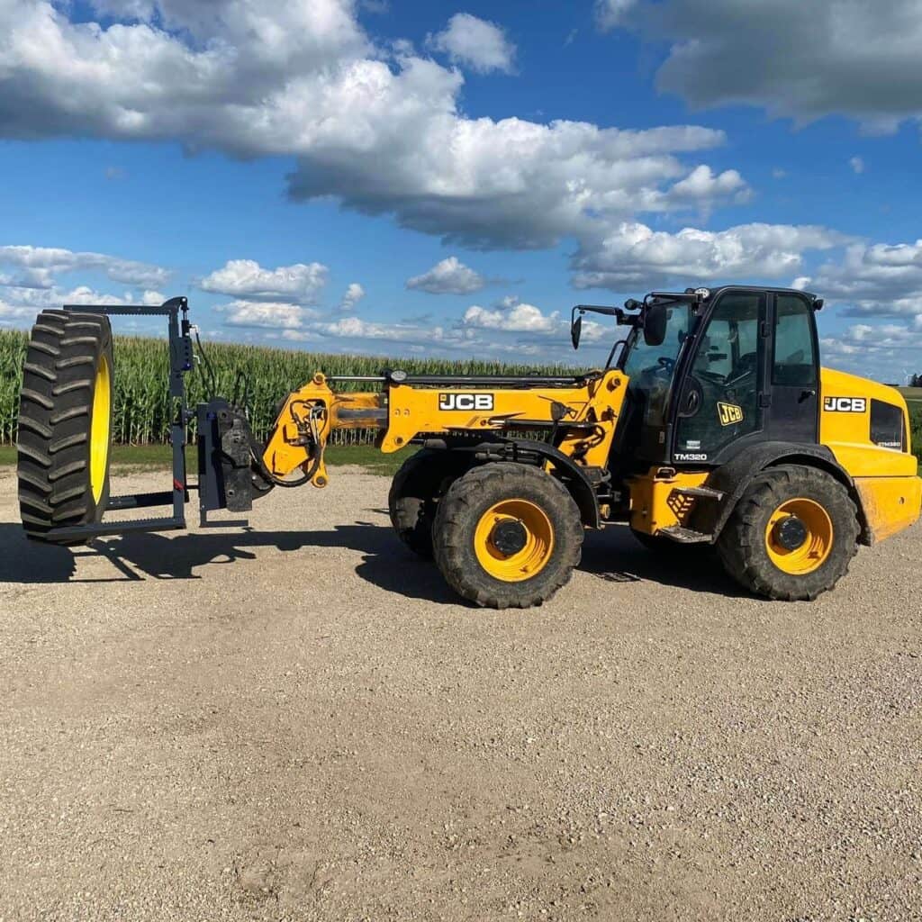 JCB telehandler using ECHO OG tire handler attachment to move large agricultural tire