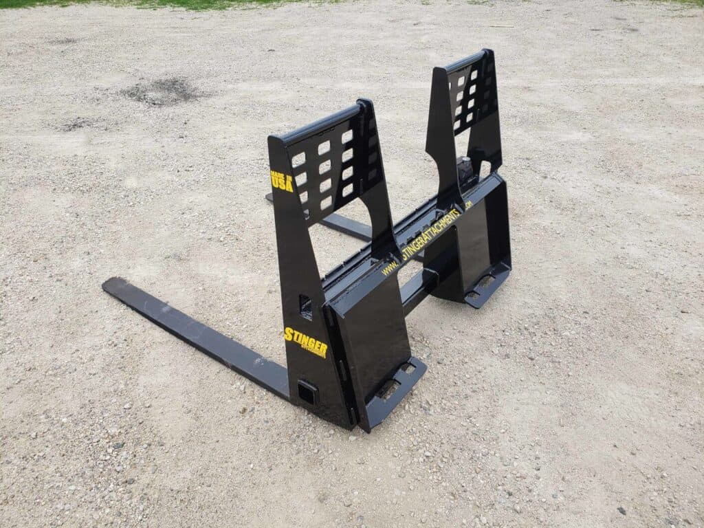 Stinger skid steer pallet fork attachment front angle view showing adjustable fork spacing and reinforced frame