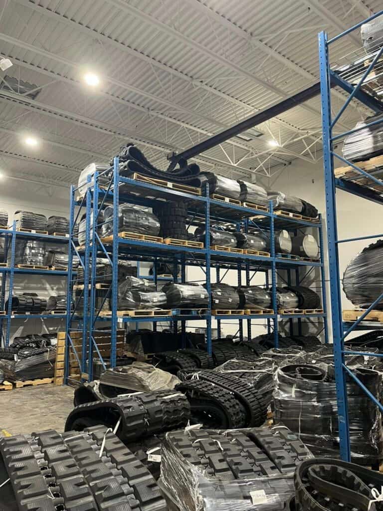 Heavy duty rubber track for skid steer track loader displayed in equipment warehouse for replacement track sales
