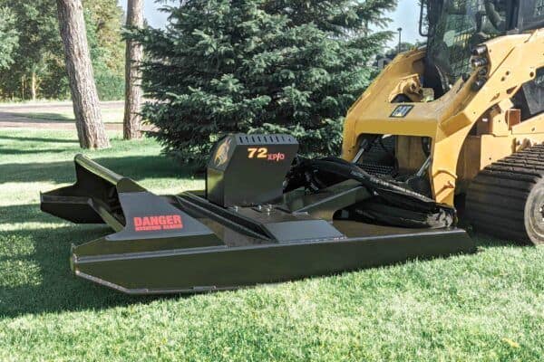 Brush Wolf 72 inch extreme duty skid steer brush cutter clearing grass and vegetation in open field