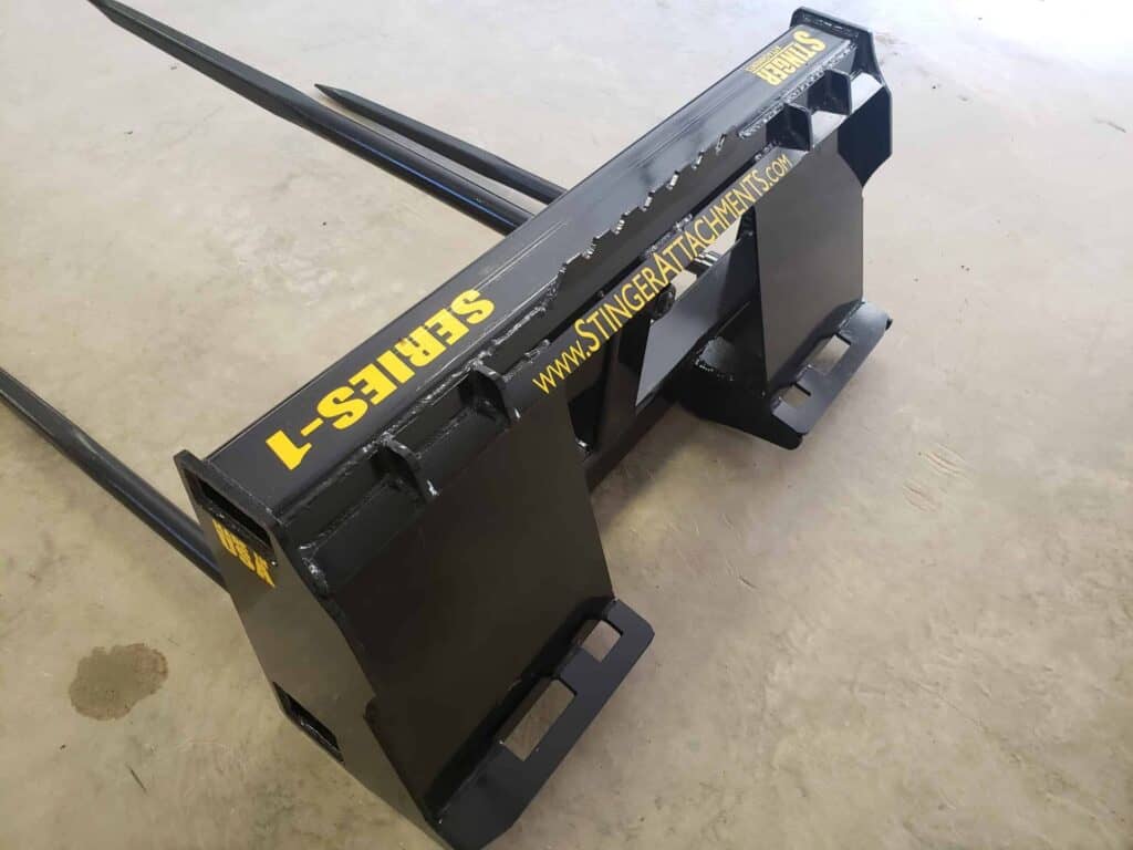 Side view of Stinger BS1 skid steer bale spear attachment for transporting round hay bales