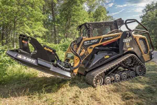 Compact track loader operating Brush Wolf Alpha Series skid steer brush cutter clearing brush in wooded terrain