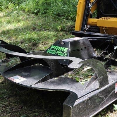 Prime Attachments rigid deck skid steer brush mower cutting heavy brush and saplings during land clearing work