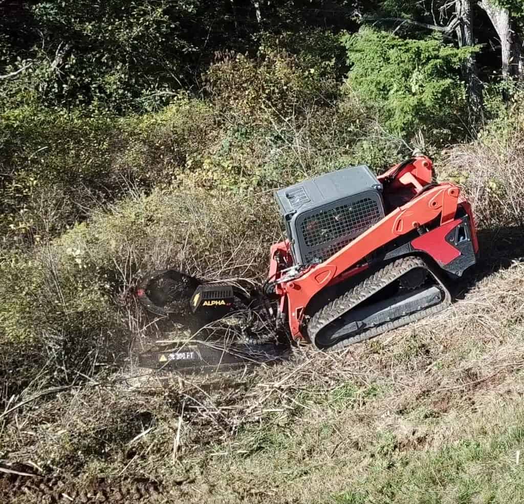 Brush Wolf Alpha skid steer brush cutter top view mounted on compact track loader cutting dense vegetation