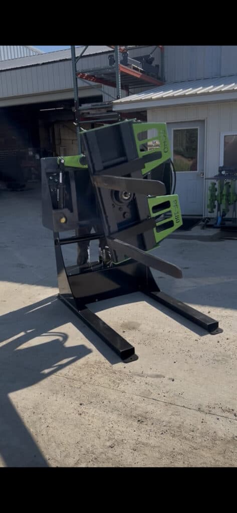 ECHO PF180 skid steer box flipper attachment lifting and rotating box near building exterior jobsite