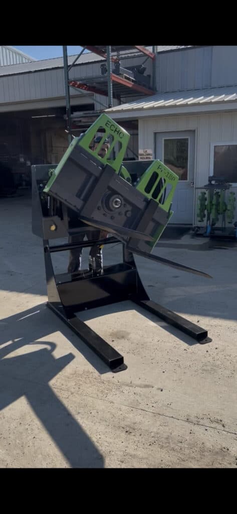 ECHO PF180 skid steer box flipper attachment rotating large material box on jobsite near building