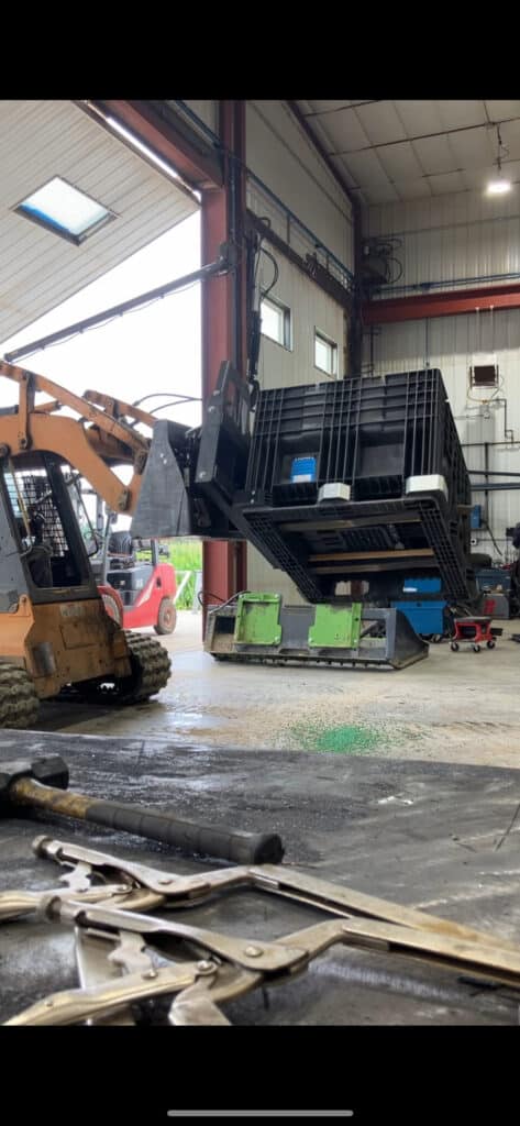 ECHO PF180 skid steer box flipper attachment side angle showing rotating mechanism and mounting plate