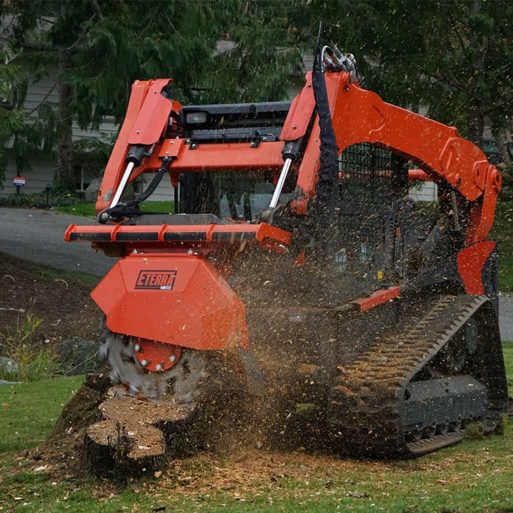 Eterra Vortex skid steer stump grinder attachment grinding large tree stump during land clearing and property maintenance