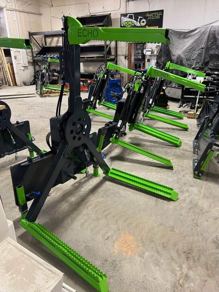 ECHO OG skid steer tire handler attachments lined up inside fabrication shop ready for shipment