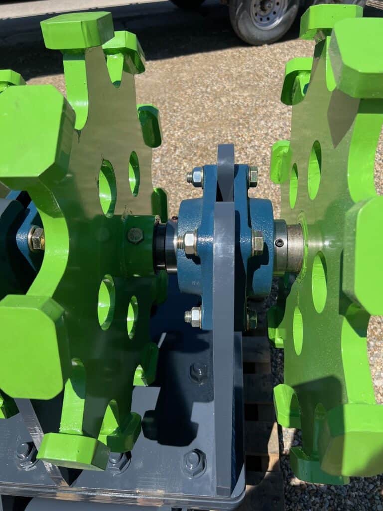 Close up of excavator compaction wheel with steel cleats for trench backfill and soil compaction