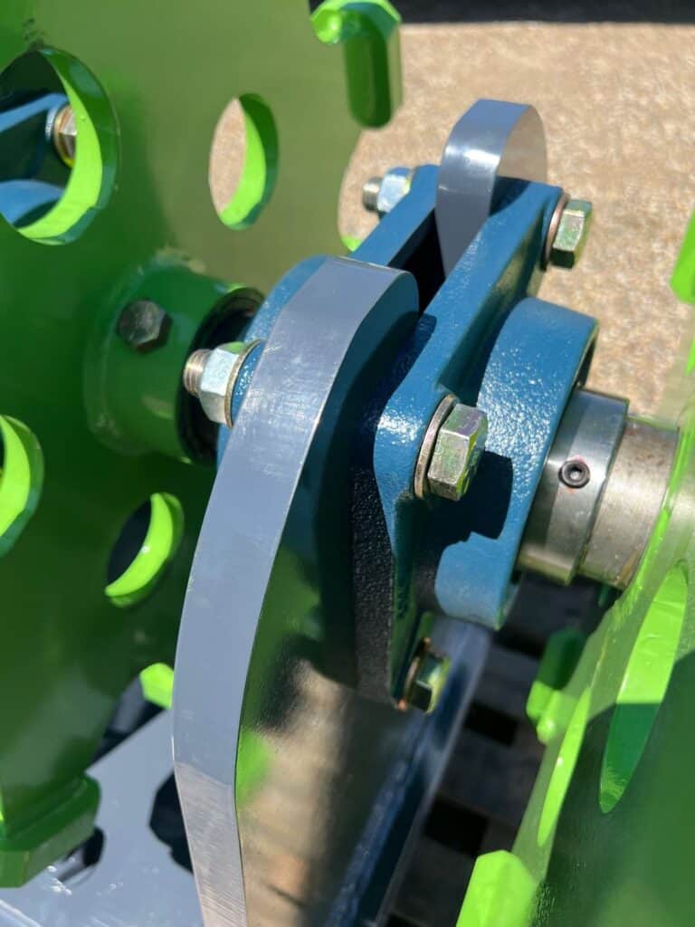 Close up of excavator compaction wheel with steel cleats for trench backfill and soil compaction