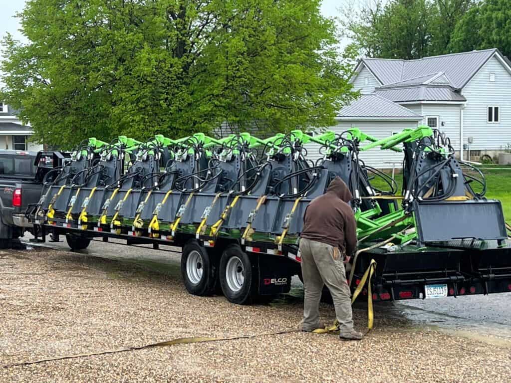 Trailer loaded with multiple ECHO OG skid steer tire handler attachments ready for delivery