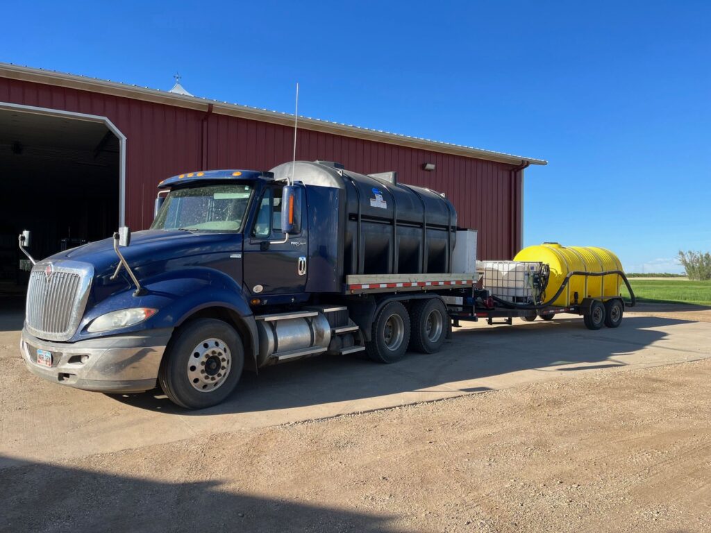 Removable semi tractor flatbed tender truck setup with agricultural tanks installed