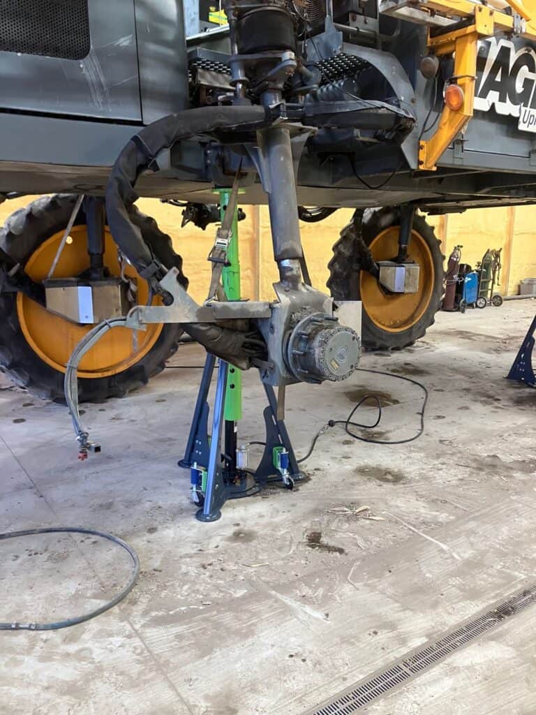 ECHO 20 ton pneumatic agricultural sprayer jack lifting high clearance Hagie crop sprayer during farm equipment maintenance