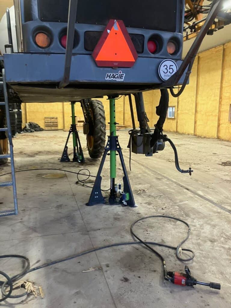Rear view of agricultural sprayer raised using ECHO 20 ton pneumatic sprayer jack