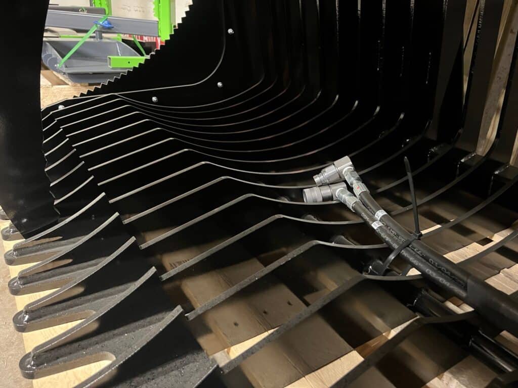 Interior tines and hydraulic cylinder detail on Stinger CROG compact tractor rock grapple attachment