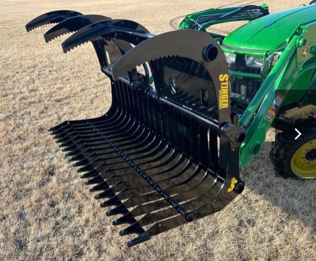 Stinger CROG compact tractor grapple attachment mounted on loader in open field
