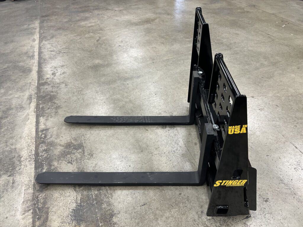 Stinger skid steer pallet fork attachment side view designed for lifting pallets, lumber and construction materials