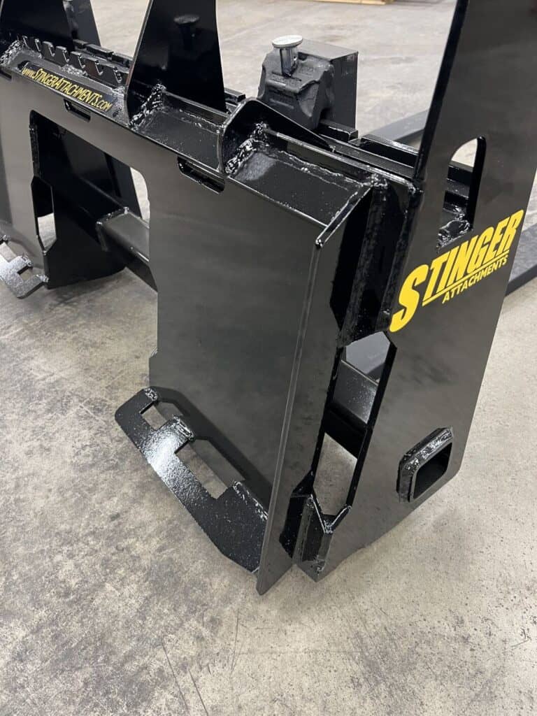 Close up of Stinger skid steer pallet fork carriage frame showing heavy duty steel construction and quick attach plate