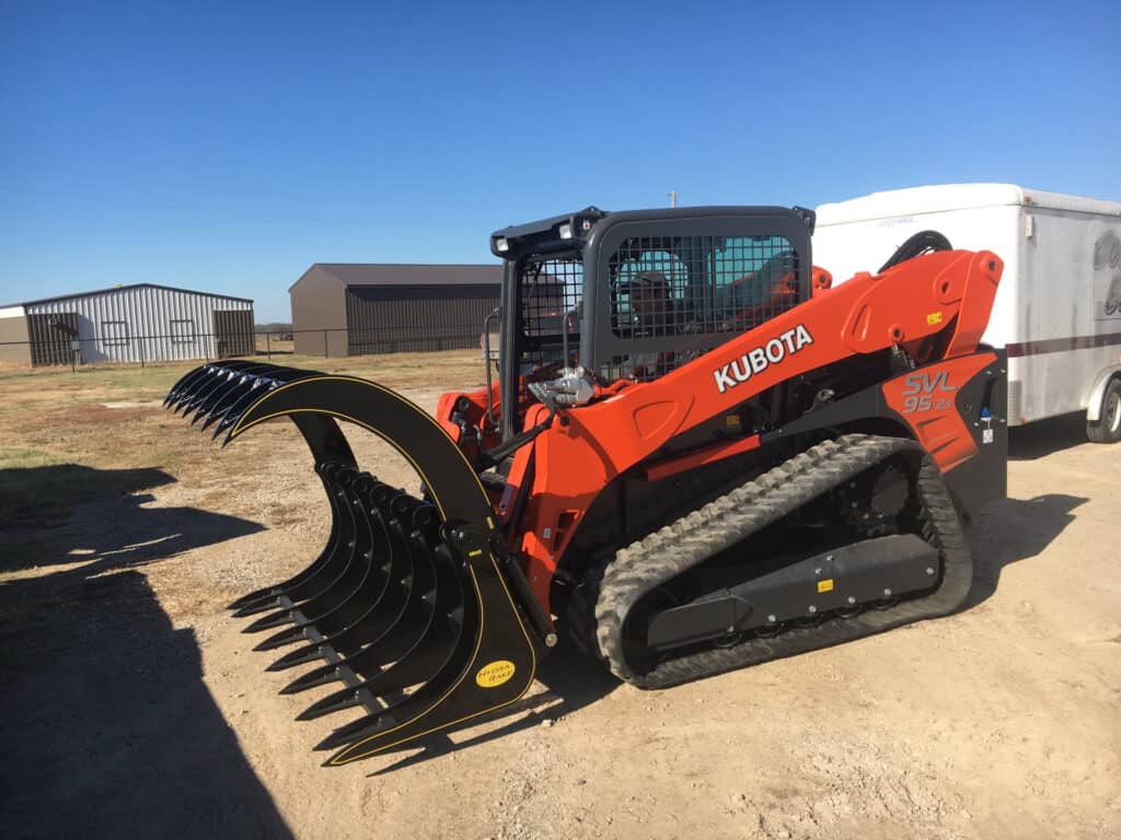 M&M Hydra Rake Extreme attachment mounted on Kubota compact track loader outdoors
