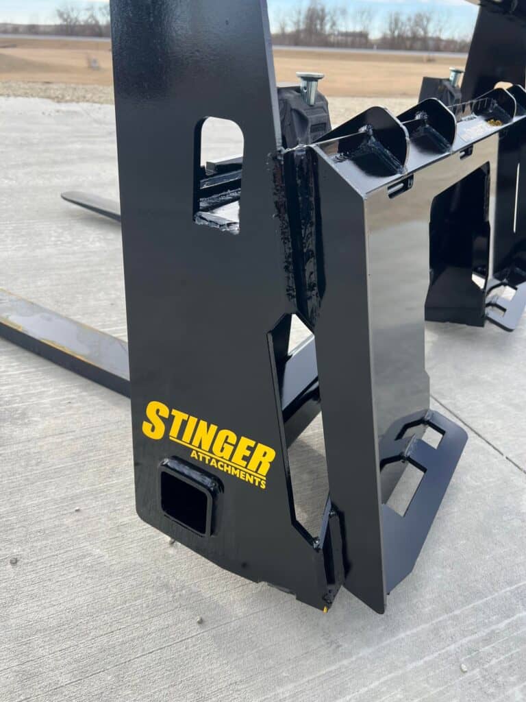 Stinger skid steer pallet forks side view showing fork spacing, carriage design, and durable build for material handling
