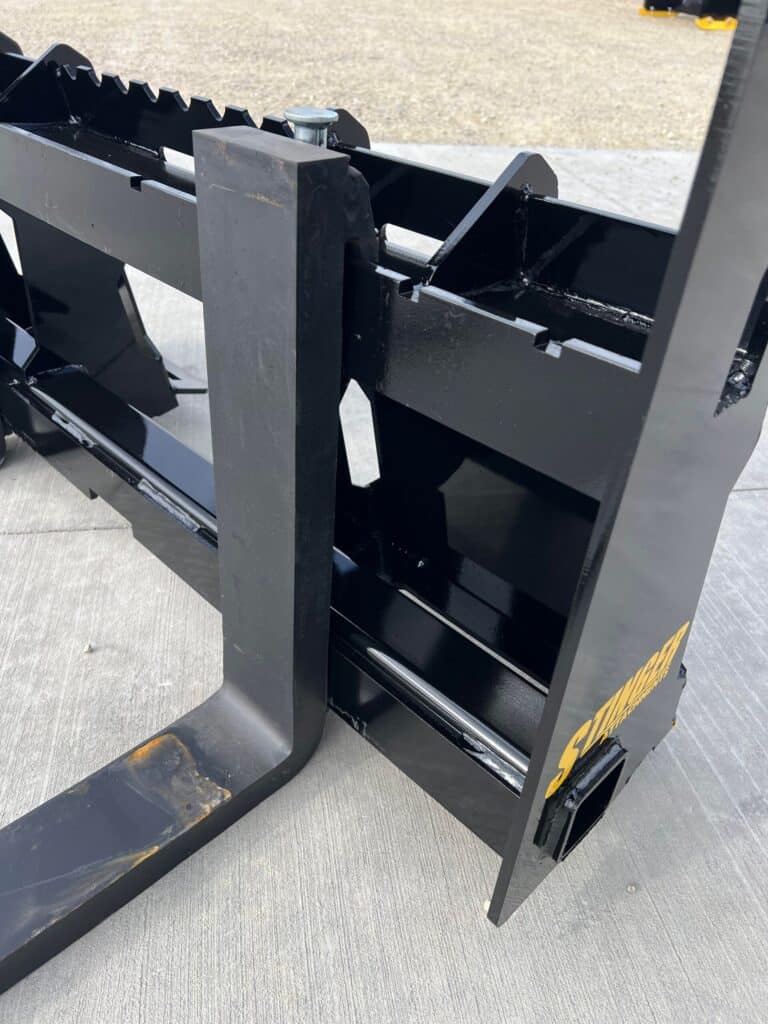 Stinger skid steer pallet forks carriage detail showing mounting plate, fork positioning, and reinforced back frame structure