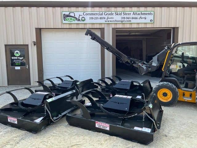 Prime Attachments direct drive skid steer brush mower mounted inside shop showing attachment frame and hydraulic drive system