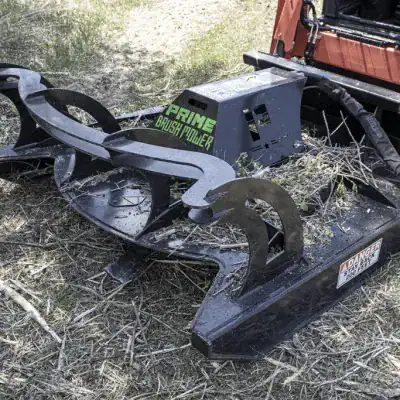 Prime Attachments direct drive skid steer brush mower actively cutting dense vegetation showing performance and blade speed