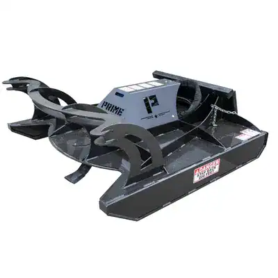 Prime Attachments direct drive skid steer brush mower mounted inside shop showing attachment frame and hydraulic drive system