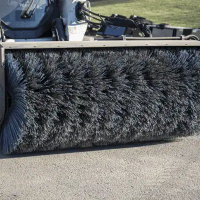 Prime Attachments skid steer power sweeper close up showing dense poly bristles for sweeping dirt, debris, and gravel