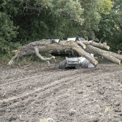 Prime Attachments skid steer rock and brush grapple moving large log pile showing high clamp force for heavy material
