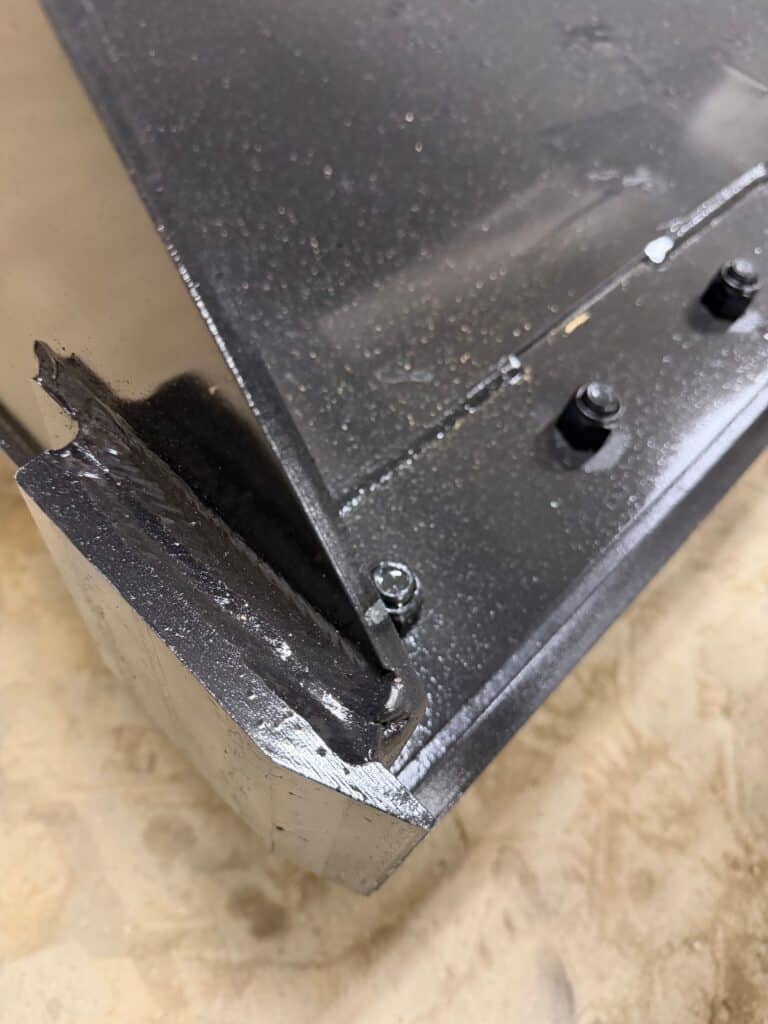 Close up of Prime Attachments high capacity skid steer grapple cutting edge and reinforced steel bucket floor