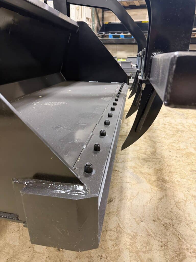 Prime Attachments high capacity skid steer grapple interior view showing cutting edge and tine spacing