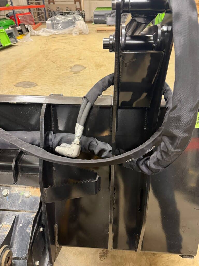 Prime Attachments high capacity skid steer grapple hydraulic system close up showing hoses fittings and cylinder