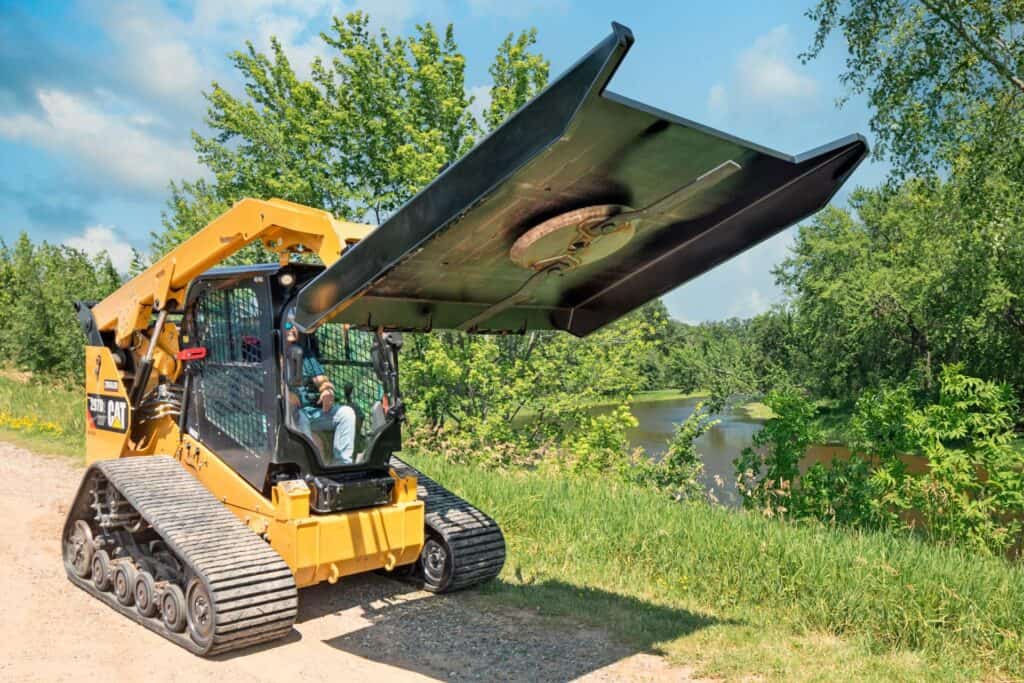 Skid steer running Brush Wolf SD7200 brush cutter clearing grass and brush