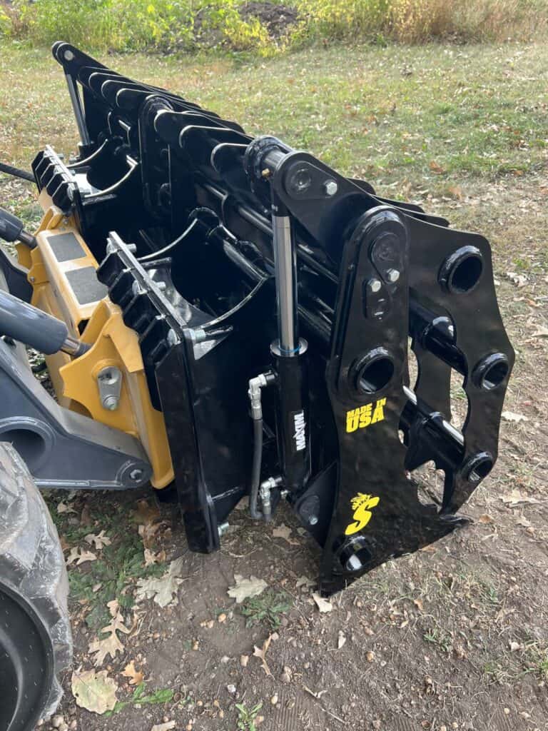 Stinger CC skid steer clam grapple side angle showing tine spacing, frame strength, and overall grapple structure