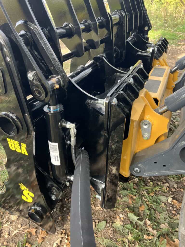 Stinger CC skid steer clam grapple close up of hydraulic cylinders and linkage showing reinforced pivot points and durability