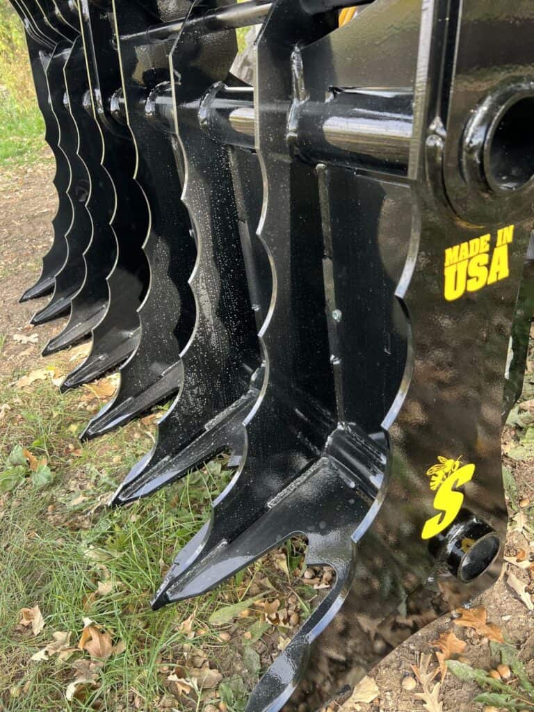 Stinger CC skid steer clam grapple pivot and hinge detail showing thick steel joints built for long term heavy use