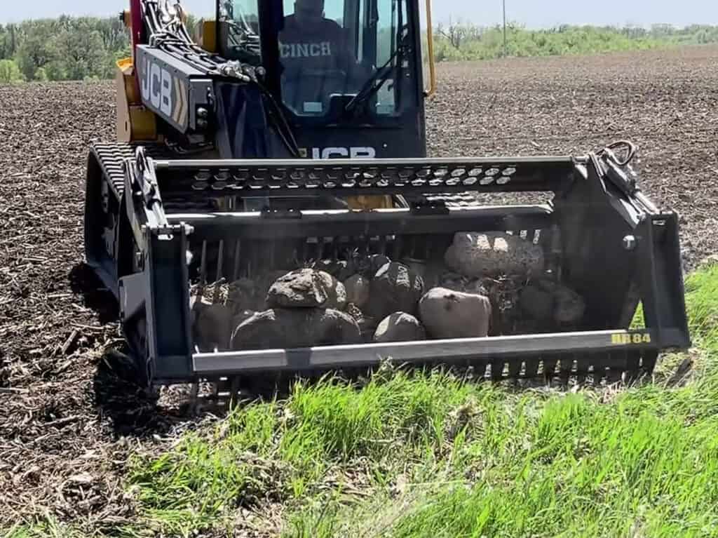 Stinger RK skid steer rock bucket loaded with rocks showing high capacity and efficient material handling