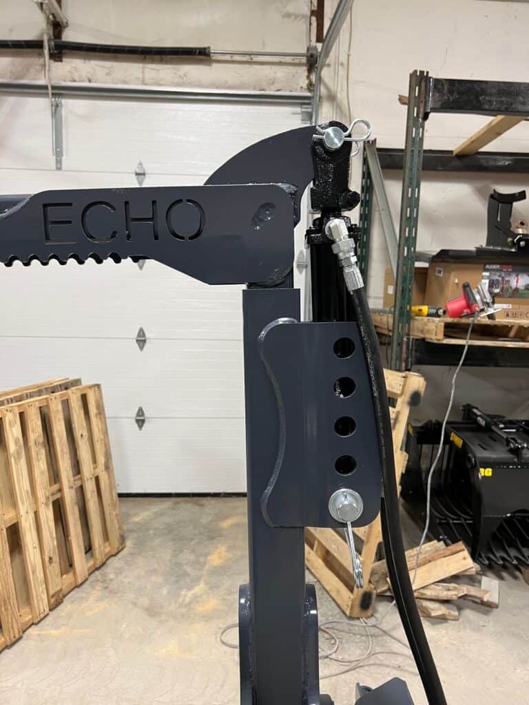 Close up steel boom arm with ECHO branding on OG skid steer tire handler attachment