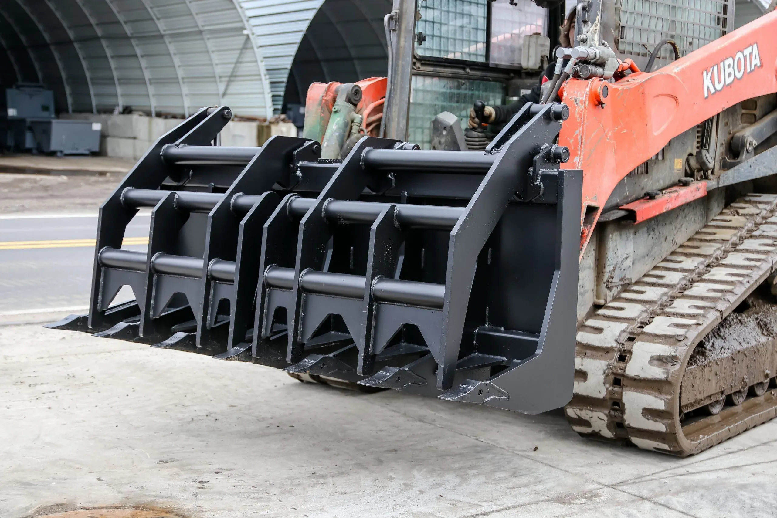 Kubota compact track loader equipped with ES Vertical Extreme grapple for land clearing and log handling