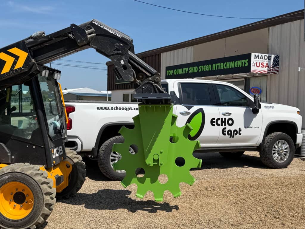 ECHO 48 inch skid steer compaction wheel suspended from a JCB loader showing the large steel compaction wheel