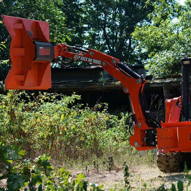 Eterra Raptor boom arm with cyclone mower reaching over ditch showing extended reach for clearing hard to access areas