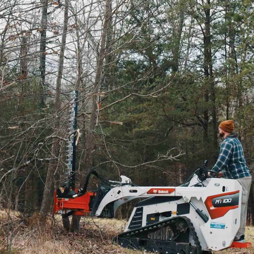 Eterra mini skid steer sickle bar mower cutting branches showing clean cut performance and controlled trimming