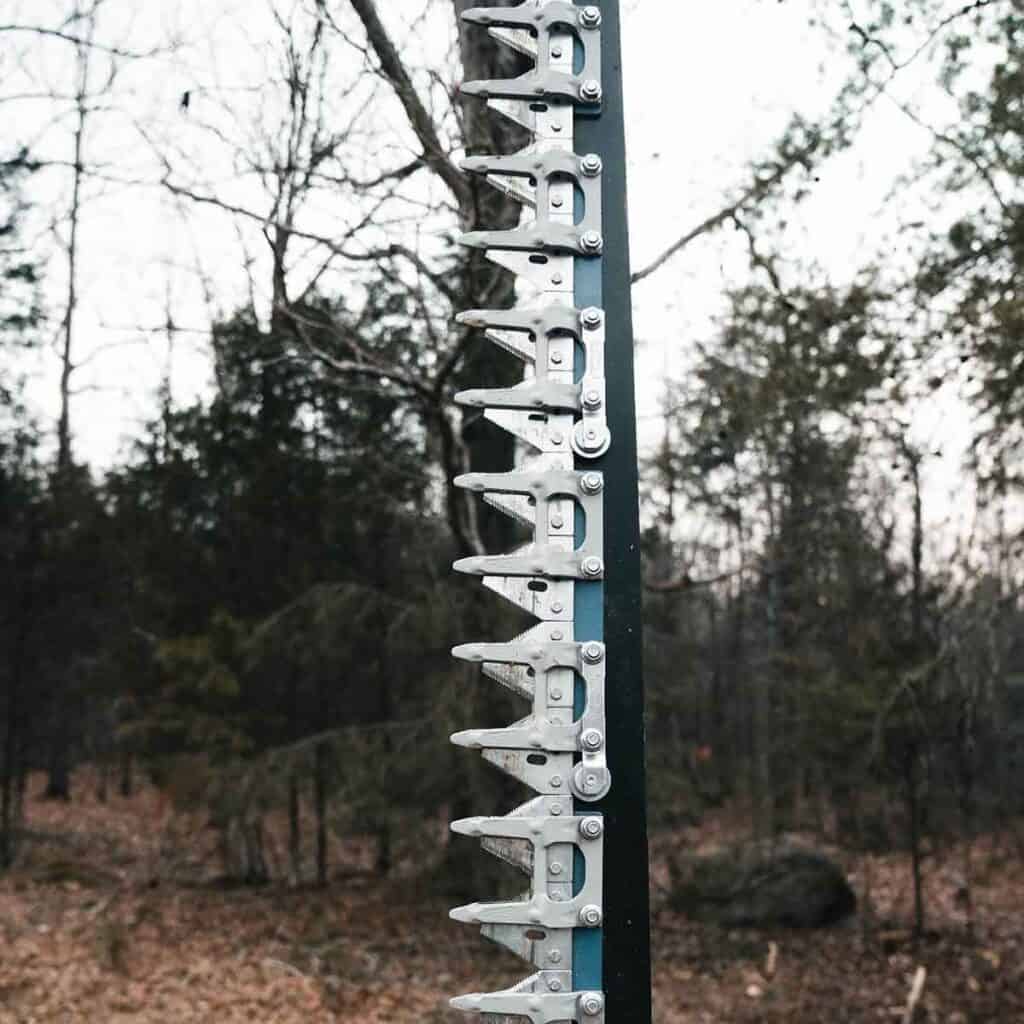 Eterra mini skid steer sickle bar mower blade detail showing serrated cutting teeth for brush and limb removal
