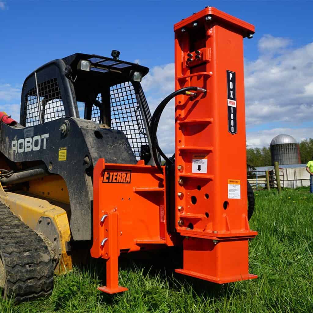 Eterra PDX-1000 skid steer post driver attachment mounted on skid steer during farm fence post installation