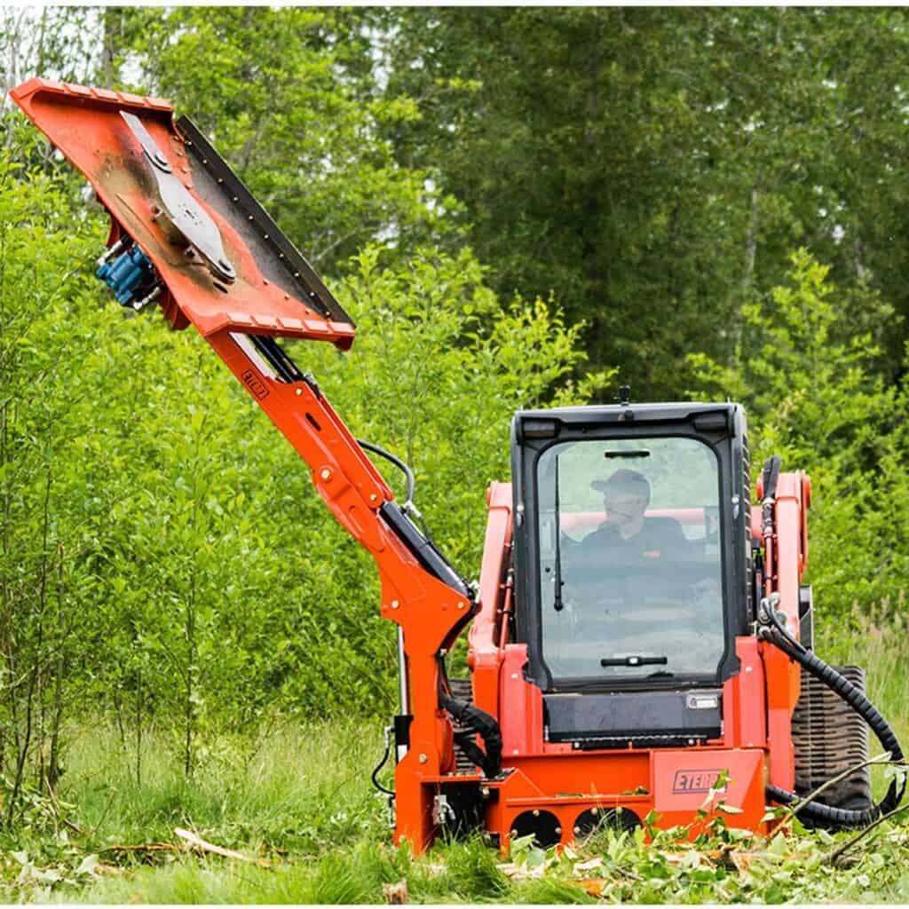 Eterra Raptor skid steer boom mower attachment cutting vegetation on roadside slopes