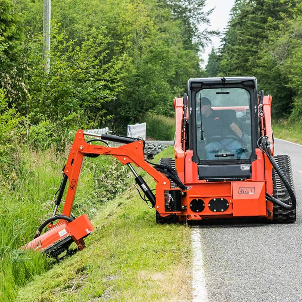 Eterra Raptor skid steer boom mower attachment cutting vegetation along trails and roadsides