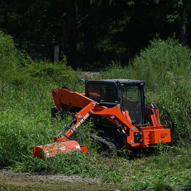 Eterra Raptor boom arm operating in wooded area showing side reach for brush clearing and vegetation management